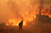 En brannmann står foran store flammer i et røykfylt landskap under Canyon-brannen i California.