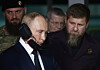 Vladimir Putin står foran mens Ramzan Kadyrov ser på under et besøk ved en militær treningsarena.