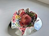 En fargerik blomsterformet bolle med en rød nektarin oppi.