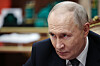 Vladimir Putin sitter ved et bord og ser alvorlig ut under et møte innendørs.