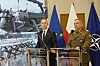 To polske forsvarstopper står ved talerstoler foran EU-, Polen- og NATO-flagg i Warszawa.