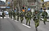 En gruppe soldater i kamuflasjeuniformer marsjerer i kolonne langs en bygata i Stockholm.