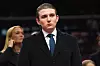 Barron Trump står i dress foran et publikum under et innendørs innsettelsesevent i Capital One Arena.