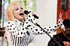 Dolly Parton opptrer med mikrofon på en TV-scene, iført hvit og svart polkadottopp og stripet kjole.