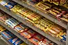 Butikkhylle fylt med ulike sjokoladeprodukter i innpakning, vist i skrå vinkel.