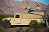Sandfarget Humvee med radar og laserutstyr står parkert foran fjell i ørkenlandskap.