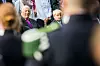 Kong Harald og prins Sverre-Magnus sitter blant gjester på hagefest i Slottsparken.