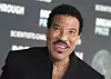Lionel Richie smiler på rød løper foran Breakthrough Prize-bakgrunn i Los Angeles.