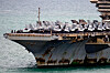 Hangarskipet USS Abraham Lincoln ved kai med flere jagerfly på dekket.