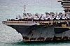 Hangarskipet USS Abraham Lincoln ved kai med flere jagerfly på dekket.