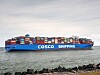 Et COSCO Shipping-containerskip med mange fargede containere seiler på sjøen.