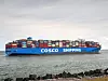 Et COSCO Shipping-containerskip med mange fargede containere seiler på sjøen.