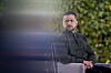 Volodymyr Zelenskyj sitter utendørs i Kyiv med grønn bakgrunn i et portrettlignende bilde.