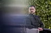 Volodymyr Zelenskyj sitter utendørs i Kyiv med grønn bakgrunn i et portrettlignende bilde.