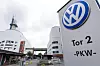 VW-logo ved Volkswagen-fabrikken i Osnabrück med bygninger og inngang i bakgrunnen.