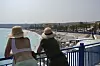 To personer står ved et rekkverk og ser ut over stranden og Middelhavet i Nice.