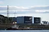 Kårstø prosessanlegg med Equinor-bygg, vindturbin og industriområde ved sjøen.