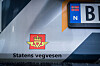 Nærbilde av Statens vegvesen-logo og tekst på et kjøretøy.