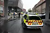 Politibil står på en våt gate ved Kuben videregående skole, omgitt av sperrebånd og flere utrykningskjøretøy.