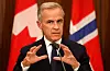 Mark Carney taler ved en mikrofon foran Canadas og Norges flagg.