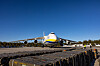 Et stort Antonov An-124-fly står på en flystripe under blå himmel.
