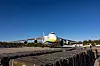 Et stort Antonov An-124-fly står på en flystripe under blå himmel.