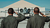 To uniformerte flygere hilser et A-10 Thunderbolt II foran en hangar på Nellis flybase.