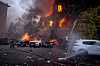 Redningsarbeidere slukker brann i en bygning med flammer i vinduene i Kyiv.