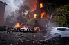Redningsarbeidere slukker brann i en bygning med flammer i vinduene i Kyiv.