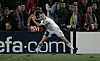Craig Bellamy i Liverpool-drakt feirer mål mot Barcelona med en golfslag-gest foran UEFA.com-skilt.