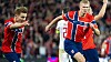 Norske fotballspillere i røde drakter løper i angrep foran fulle tribuner.