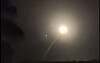 Sterkt lys med skrå lysstripe på mørk nattehimmel over lav horisont.