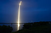 Lysende langeksponeringsspor fra en Falcon 9-rakett over Cape Canaveral om natten.