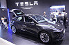 Tesla Model Y på Teslas stand under VivaTech i Paris, med besøkende rundt bilen.
