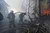 Brannfolk slukker i en utbrent byggevarebutikk i Kharkiv, med røyk, ruiner og flammer.