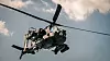 Amerikansk AH-64 Apache-helikopter flyr mot skyet himmel under øvelse i Grafenwöhr.