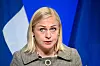 Elina Valtonen taler foran finske flagg under pressekonferanse i Helsingfors.