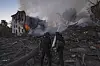 Redningsmannskaper arbeider blant ruiner mens flammer og røyk stiger fra et ødelagt boligbygg i Kramatorsk.