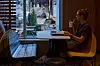 Kunde ved vinduet på McDonald’s ser mot skadet bygning i Kyiv.
