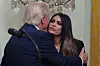 Donald Trump omfavner Kimberly Guilfoyle ved en talerstol i Det hvite hus.
