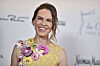 Hilary Swank i gul kjole med blomsterdetaljer foran sponsorvegg i Beverly Hills.