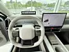 Førerplass med ratt, digitalt instrumentpanel og stor skjerm med kart i en moderne bil.