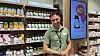 Apotekansatt foran hyller med legemidler og helseprodukter.