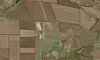 Satellittbilde av åkre og gårdsanlegg i et flatt jordbruksområde.