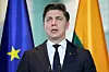 Litauens statsminister Mindaugas Sinkevicius taler ved mikrofoner foran EU-flagg i Berlin.