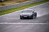 Grå Porsche kjører på våt racerbane med autovern langs venstre side. Selv på regnvåt og glatt bane kan du kjøre fort rett frem med en stor og tung elektrisk GT-bil som Polestar 5 Performance.