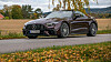 Mørk Mercedes-AMG cabriolet på landevei ved jorde og høstløv. Mercedes-AMG SL 63 S E Performance er svindyr, men også ekstremt heftig, og den treffer på alle punkter, inkludert kabrioletfølelsen.
