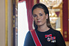 Kronprinsesse Ingrid Alexandra med ordensbånd og medaljer i et rom på Slottet.