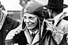 Amelia Earhart i flygerlue og pelsforet jakke, omgitt av menn i Southampton i 1928.