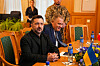 Volodymyr Zelenskyj og Masud Gharahkhani ved et møtebord med ukrainsk flagg på Stortinget.